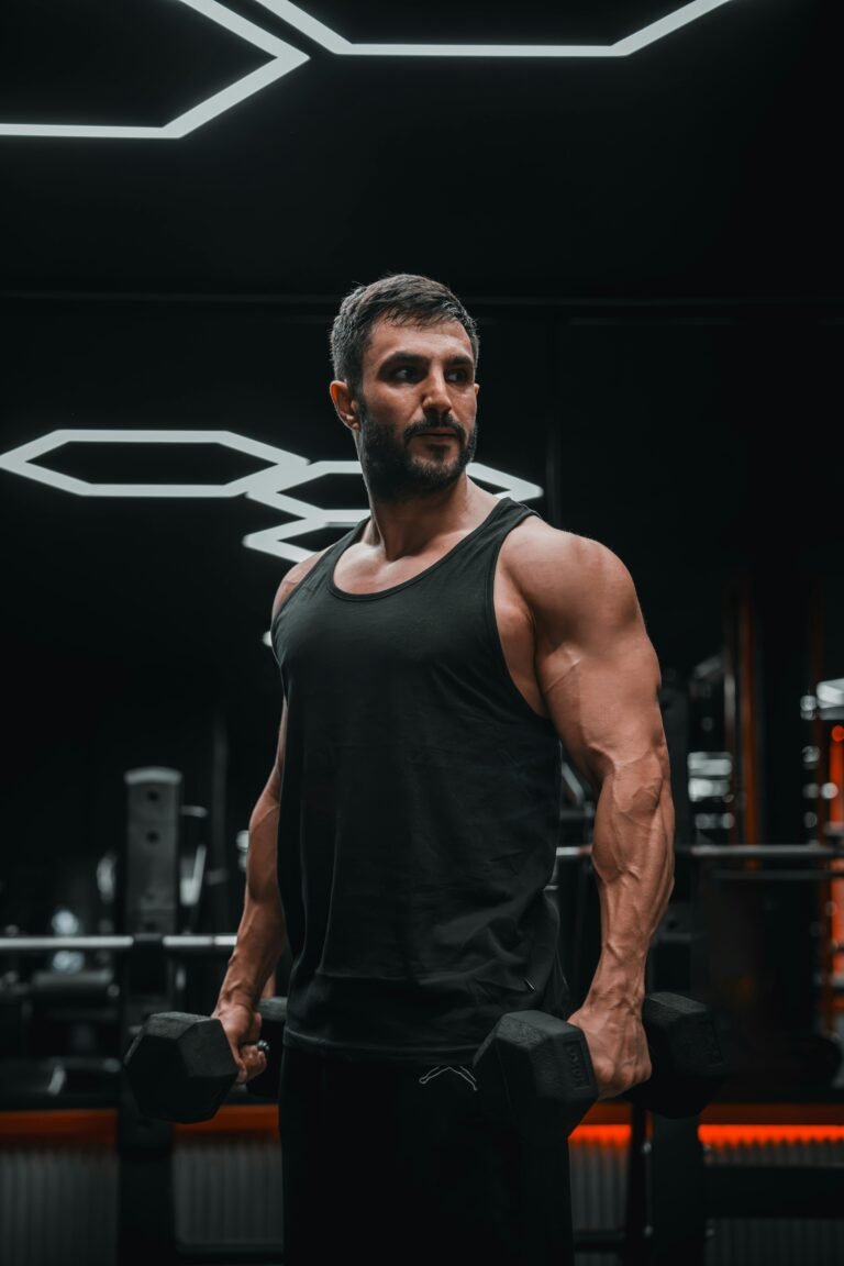 Muscular man lifting weights in a modern gym, intense workout session.